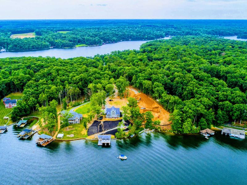 Beautiful aerial view of a private lakefront property surrounded by lush greenery, offering a perfect secluded retreat