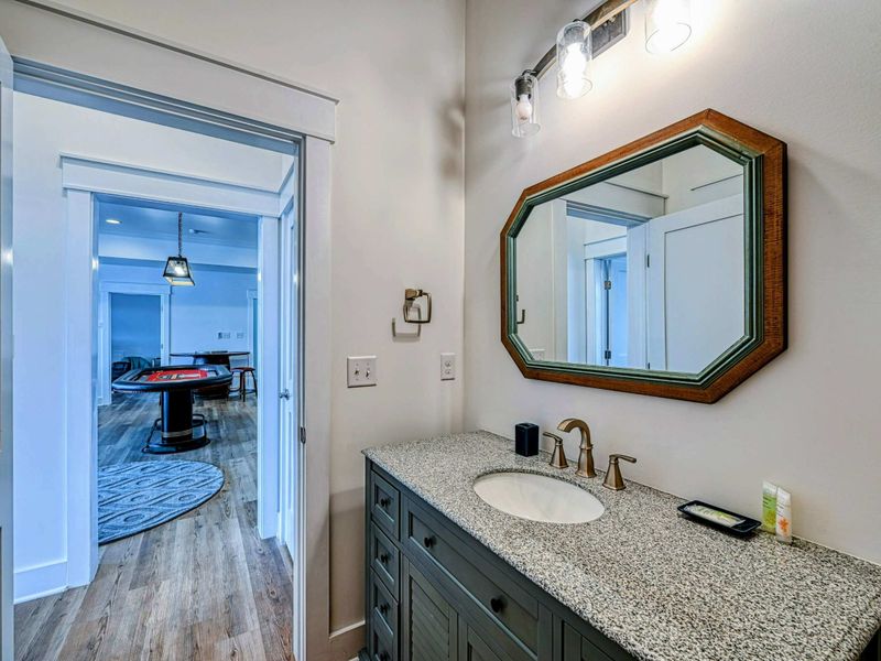 Chic bathroom with a granite vanity, stylish mirror, and easy access to the entertainment room