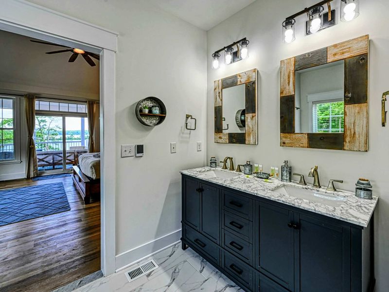 Elegant bathroom with a double vanity, rustic wooden mirrors, and modern lighting, offering a blend of comfort and style