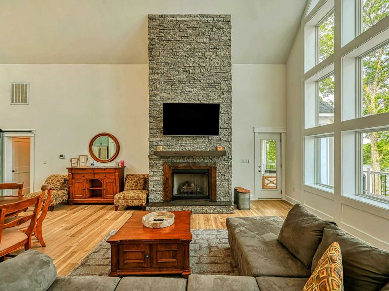 Spacious living area with a stone fireplace, large flat-screen TV, and ample seating, creating a cozy yet luxurious ambiance