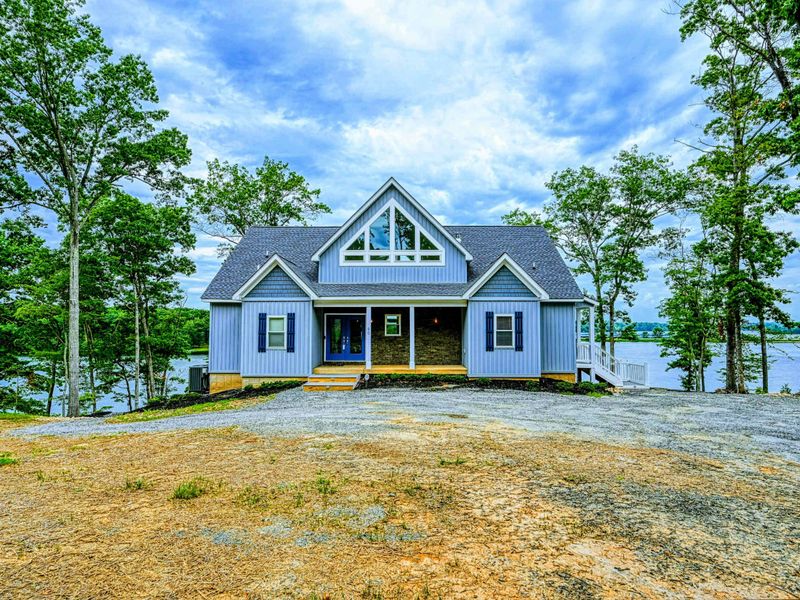 Charming lakefront home with a welcoming front entrance, surrounded by nature and offering stunning water views