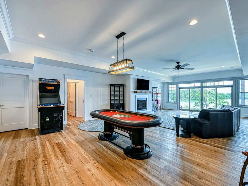 Spacious game room with a poker table, arcade machine, and comfortable seating, ideal for indoor entertainment and fun