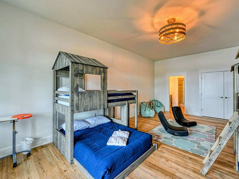 Fun and spacious kids' room with charming bunk beds, cozy seating, and plenty of play space for an enjoyable stay