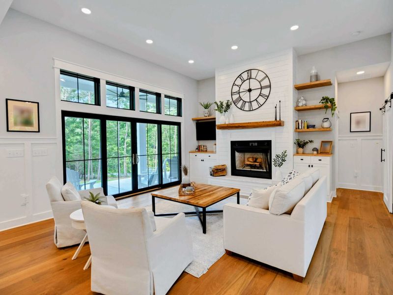Unwind in our stylish and cozy living room, complete with a warm fireplace and expansive windows that invite the beauty of the outdoors inside.
