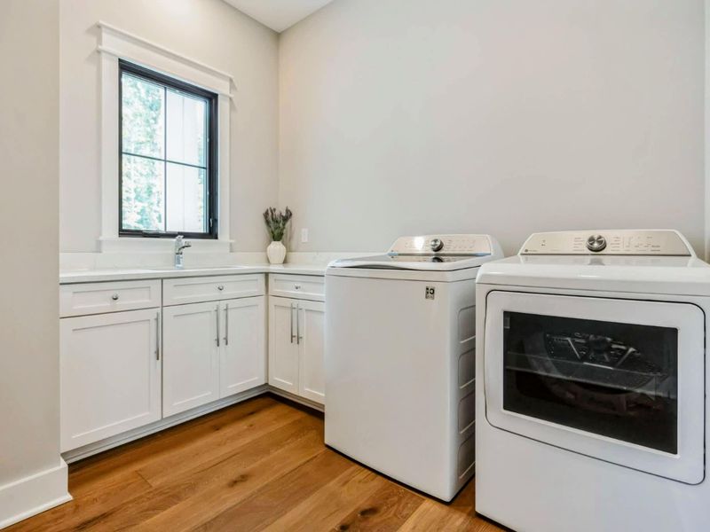Spacious and modern laundry room with a washer, dryer, and ample counter space for convenience.