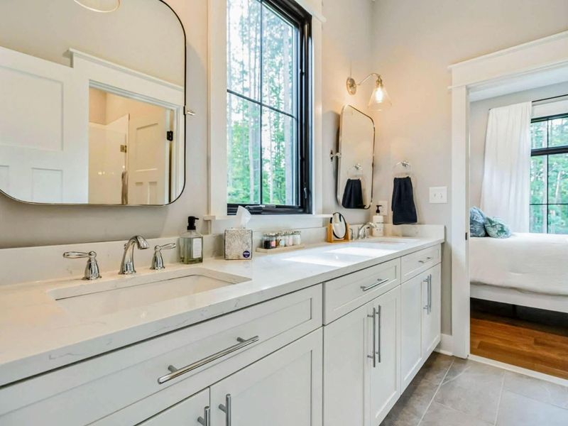 Spacious Jack and Jill bathroom featuring dual sinks, elegant finishes, and convenient access between a king and queen bedroom.