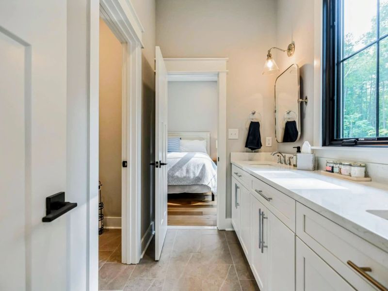 Spacious Jack and Jill bathroom featuring dual sinks, elegant finishes, and convenient access between a king and queen bedroom.