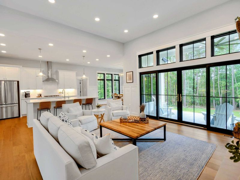 Bright and airy living room featuring a cozy fireplace, stylish furnishings, and large windows for natural light.