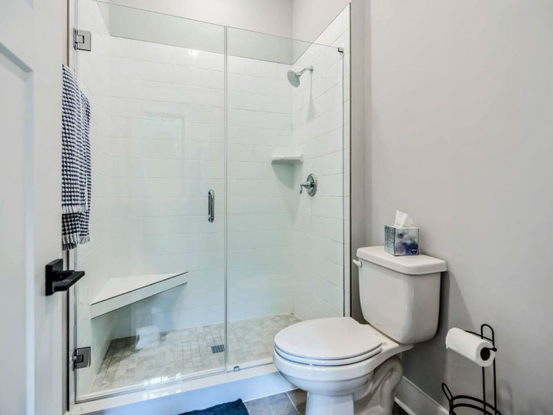 Modern bathroom with a glass-enclosed walk-in shower, tiled bench, and sleek fixtures for a comfortable stay.