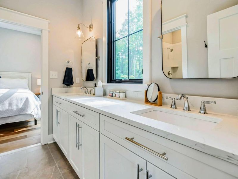 Spacious Jack and Jill bathroom featuring dual sinks, elegant finishes, and convenient access between a king and queen bedroom.