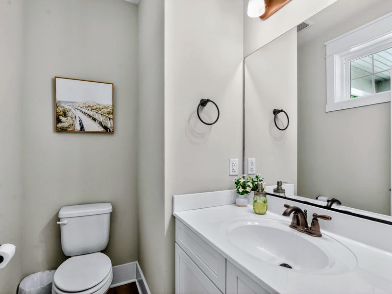 Powder Room - White vanity, bronze fixtures, and a coastal print set the tone for the rest of the home.