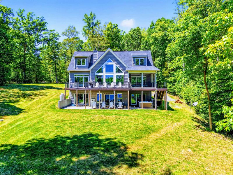 Backyard - Sprawling lawn rolls right to the water, with a screened porch above and a hot tub below for sundown soaks.