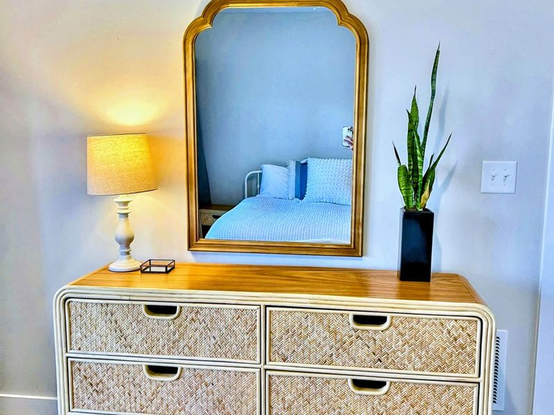 Suite 3 - A wicker dresser, gold-framed mirror, and warm touches give this king suite its own relaxed, coastal character.