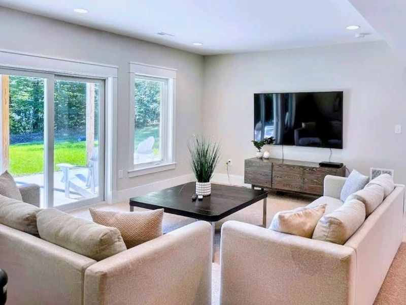 Game Room - Plush seating, a big-screen TV, and walk-out access to the yard, the easy downstairs hangout after a day on the water.