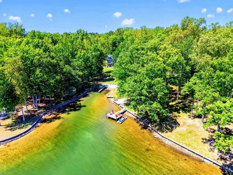 Aerial - Kayaks ready on the shore, dock at the cove's edge, your own slice of the lake from the air.