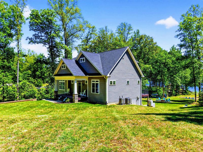 Front Exterior - The house sits just up from the water, lawn rolling down to your private beach and dock.