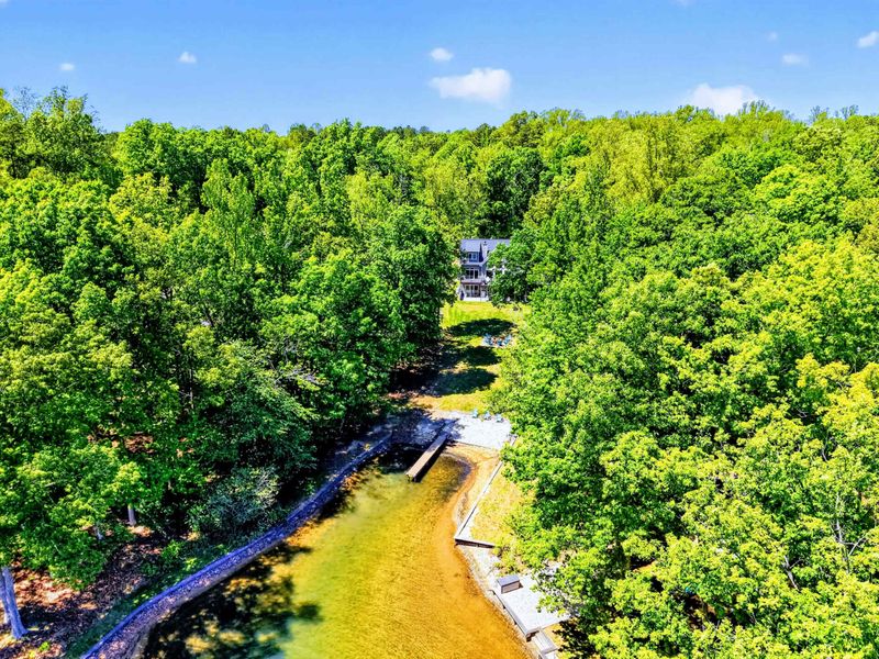 Aerial - Tucked into a private cove with your own beach and dock, the only neighbors are the trees.