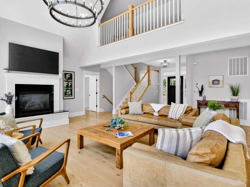 Great Room - Two-story windows, fireplace beneath the TV, and loft views from above, this is the room the trip is built around.