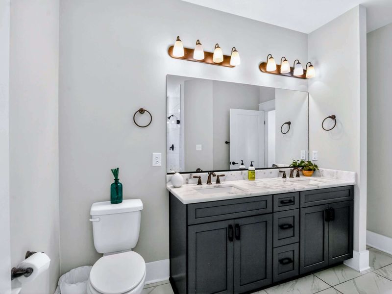 Suite 1 Bath - Marble counters, double vanity, and warm bronze fixtures, easy mornings for two.