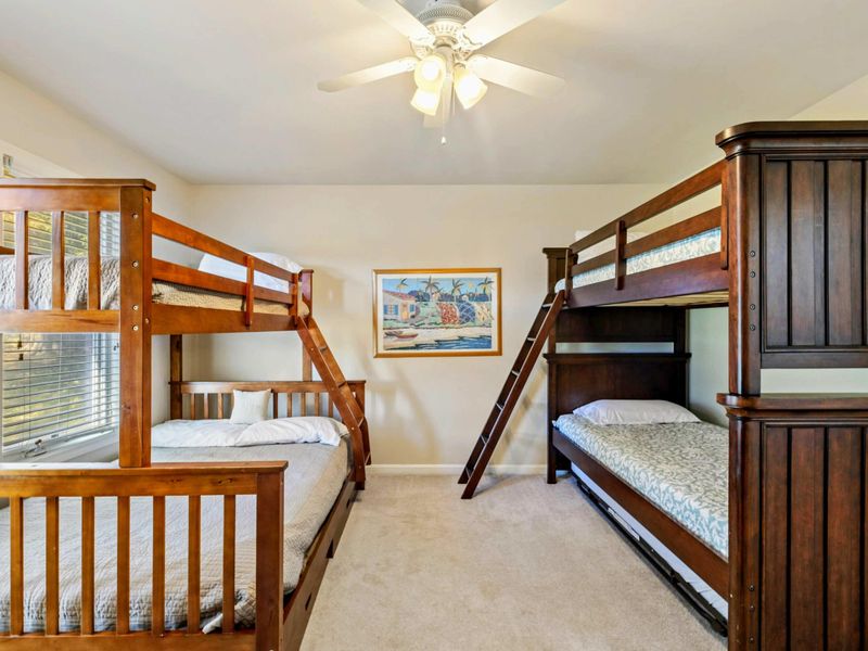Bunk Room - Alternate angle showing both bunk beds with the tropical art between them and a view into the hallway.