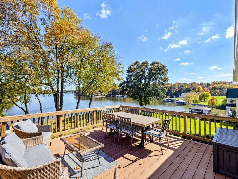 Spacious deck with comfortable seating and dining area, overlooking beautiful lake views