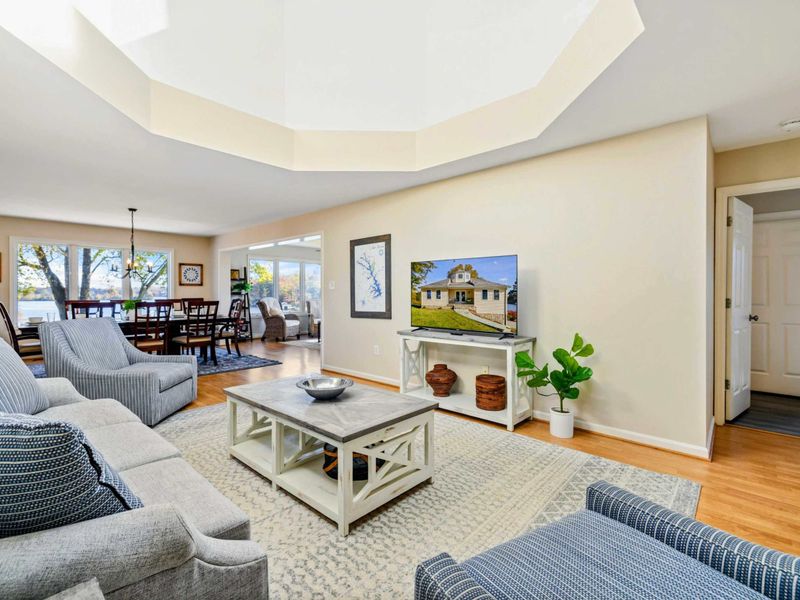 Bright and spacious living room with comfortable seating, stylish decor, and a view into the dining area