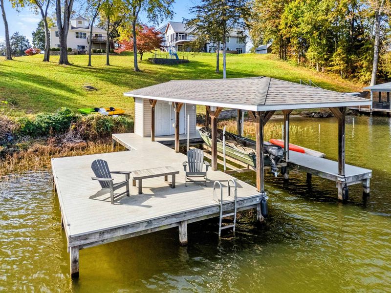 Charming private dock with seating, boat lift, and covered storage, ideal for lakefront relaxation and activities