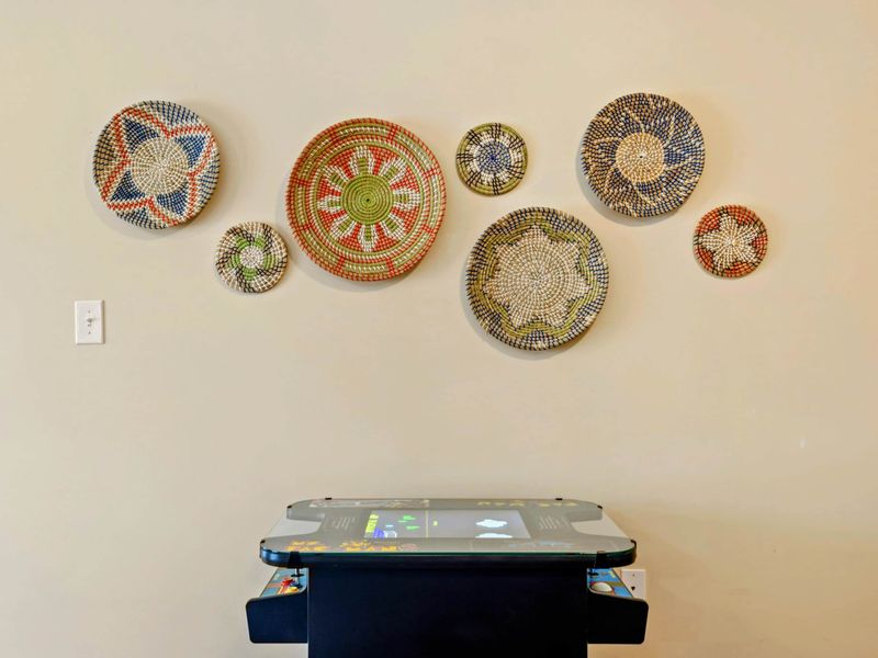 Game Room - Closeup of the retro arcade cabinet with colorful woven basket art displayed above.