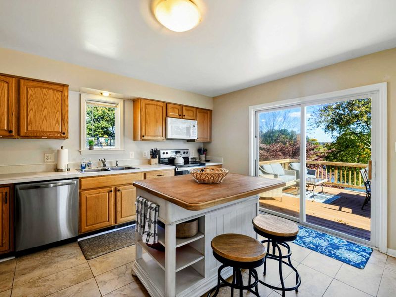 Bright kitchen with a central island and sliding doors leading to a spacious outdoor deck