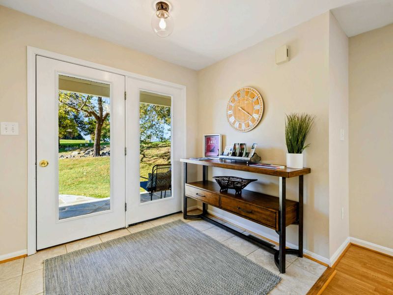 Bright and welcoming entryway with a view, featuring a stylish console table and decor