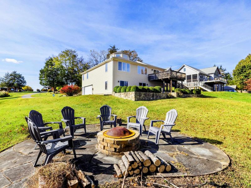 Charming fire pit area with Adirondack chairs, perfect for cozy gatherings in a spacious backyard