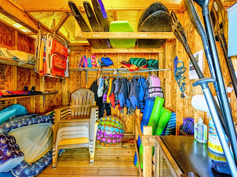 Gear up for adventure in this well-stocked shed featuring life jackets, paddleboards, and water toys, ensuring fun-filled days on the lake.