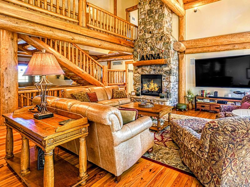 Upper Deck - Adirondack chairs and a gas grill under the timber frame roof create the perfect outdoor entertaining space with lake views.
