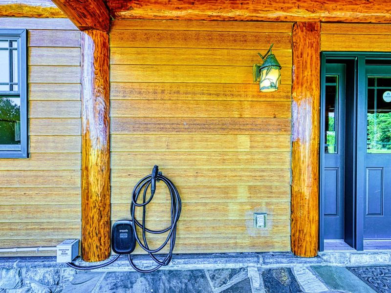 This property offers the convenience of an electric vehicle charging station, thoughtfully located under the rustic covered porch.