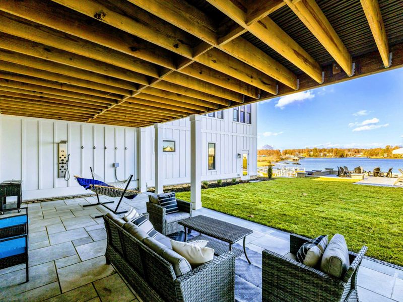 Backyard - Covered patio with hammock, rocking chairs, and lake views.