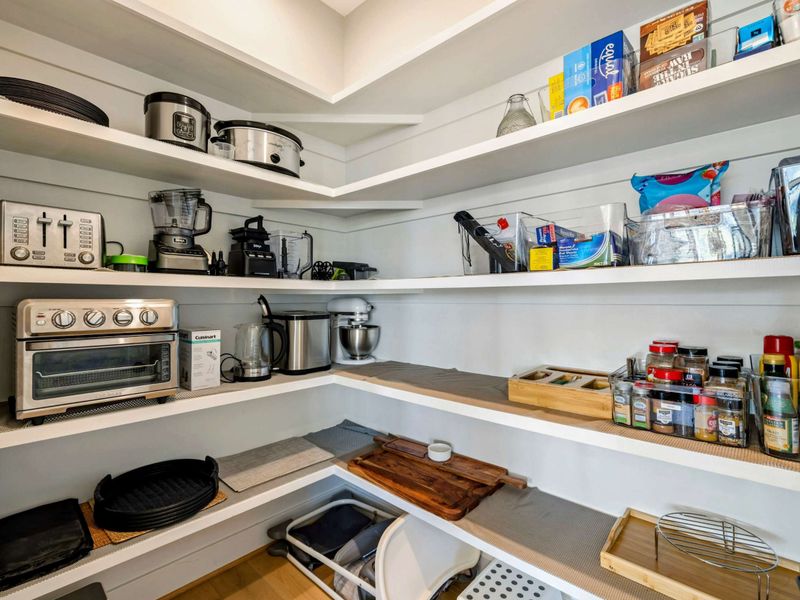 Kitchen - Walk-in pantry stocked with cookware, small appliances, and essentials.