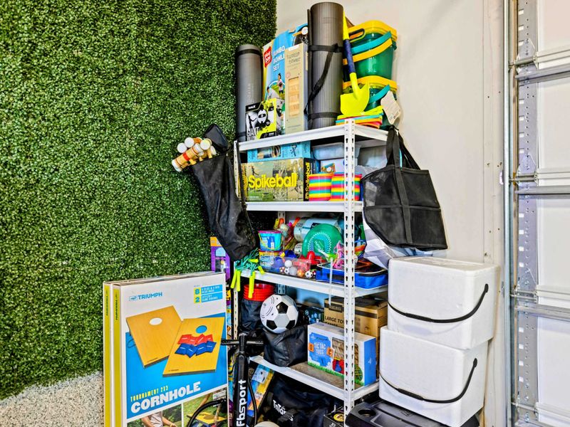 Game Room - Outdoor game equipment including cornhole and Spikeball stored nearby.