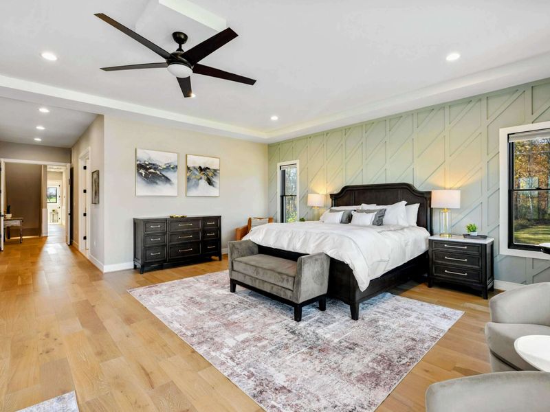 Primary Suite - Seating area at the foot of the bed with upholstered armchairs.