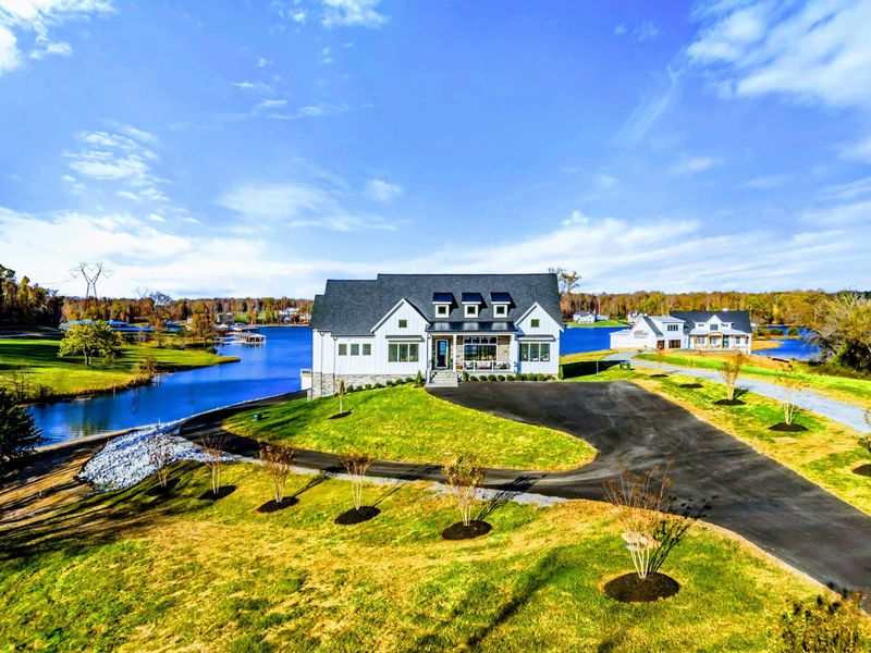 Exterior - Modern farmhouse facade from the lake side with dock in the foreground.