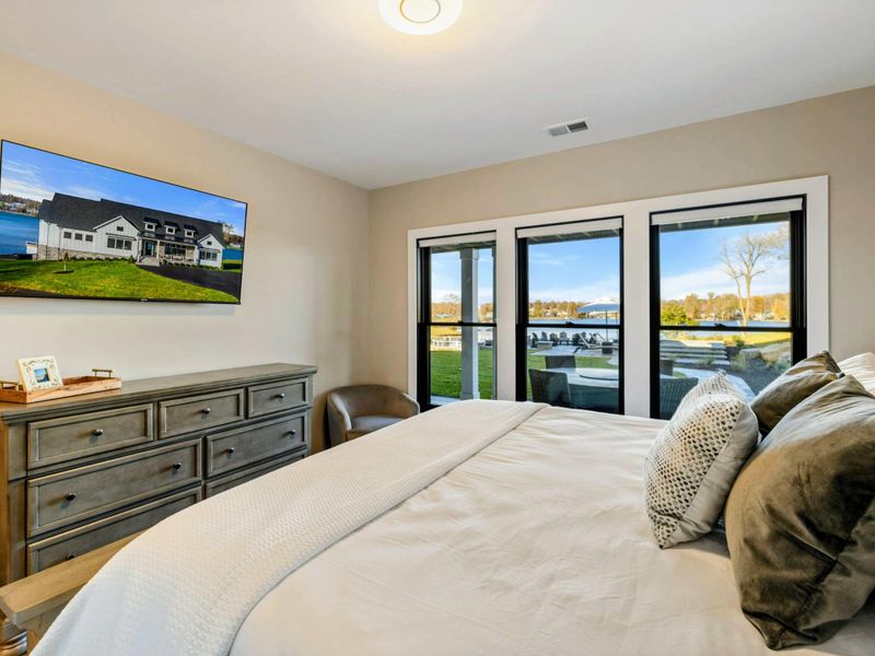 Bedroom 7 - King bed, smart TV, and en-suite bath with warm neutral tones.