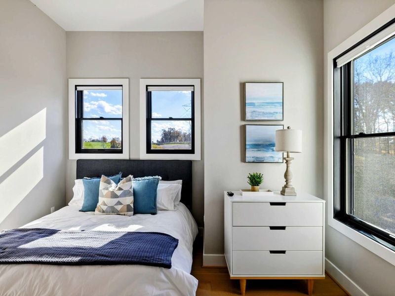 Bedroom 5 - Queen bed with large windows, stylish decor, and a cozy reading nook.