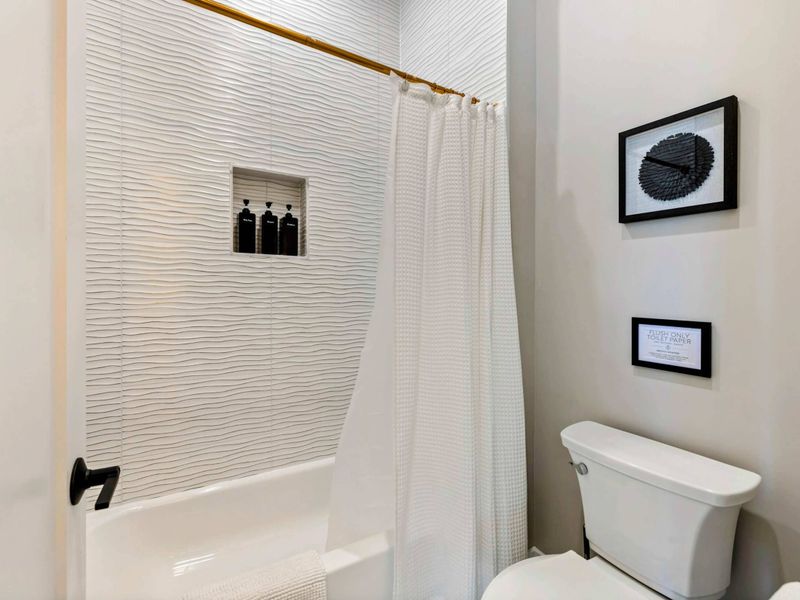 Jack and Jill Bath - Tiled shower enclosure with glass door and modern hardware.