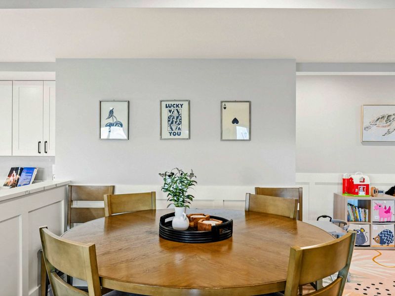 Lower Living Area - Game nook with round table, wall art, and nearby play area.