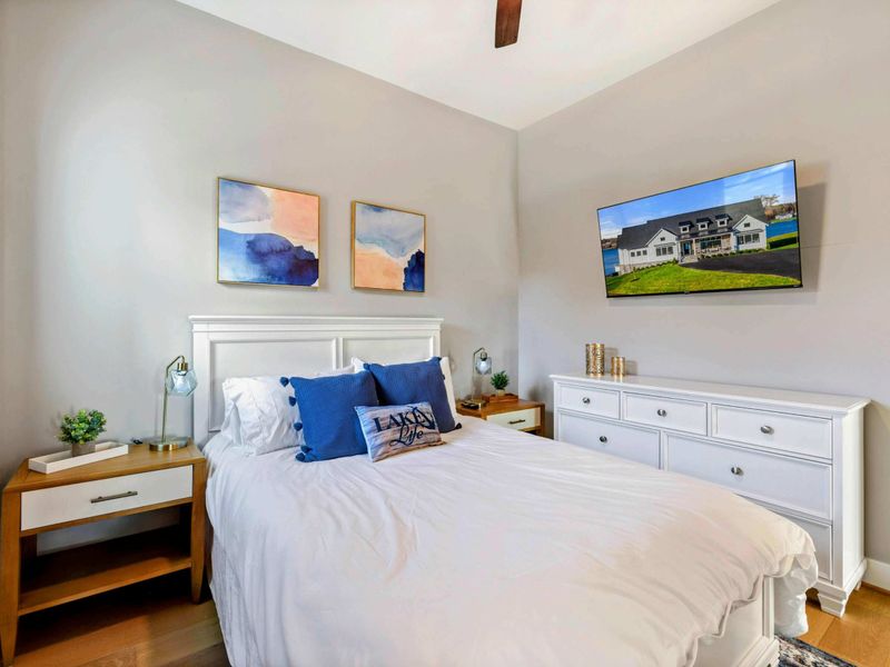 Bedroom 6 - Queen bed with blue accent pillows, modern art, and natural light.