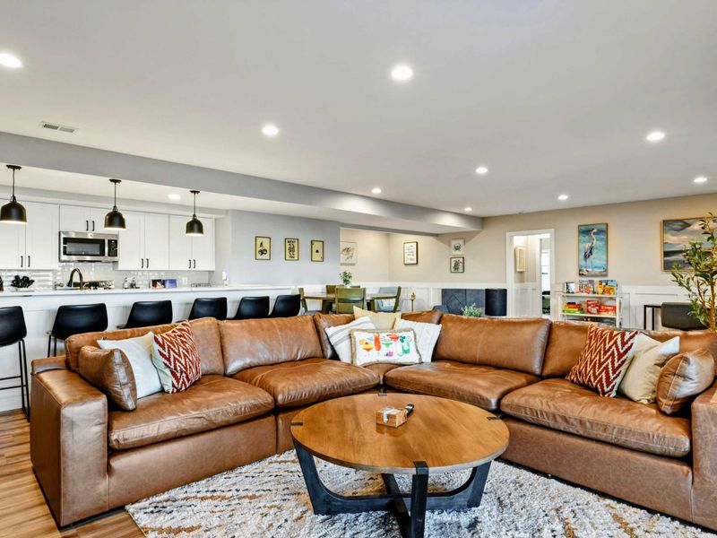 Lower Living Area - Open layout with seating area, kitchenette bar, and access to the patio.
