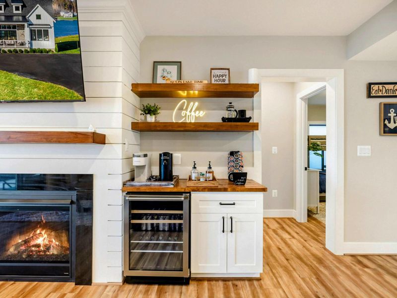 Lower Living Area - Coffee bar with open shelves, mini-fridge, and fireplace glow.