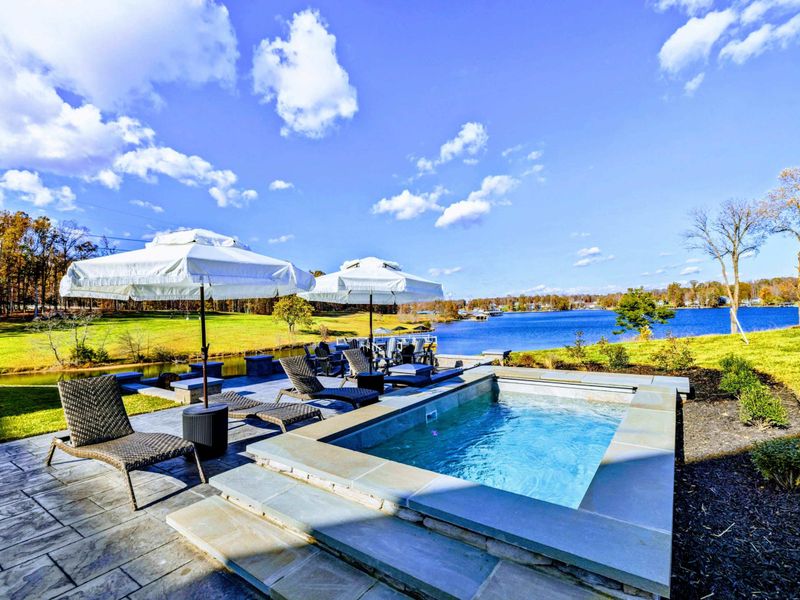 Backyard - Elevated view of the backyard with spa, firepit, and waterfront in the distance.