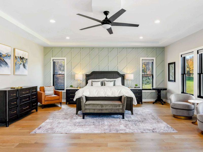 Primary Suite - King bed, daybed, seating area, and floor-to-ceiling lake views.