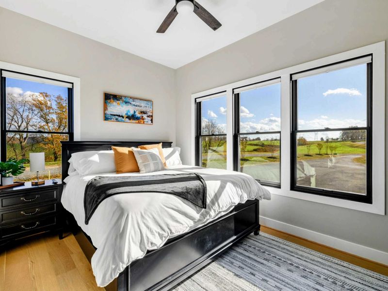 Bedroom 3 - Queen bed, scenic window views, dresser, and wall-mounted TV.