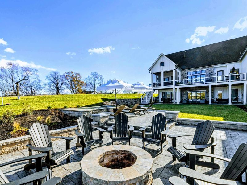 Backyard - Firepit area with Adirondack chairs and lake views through the trees.